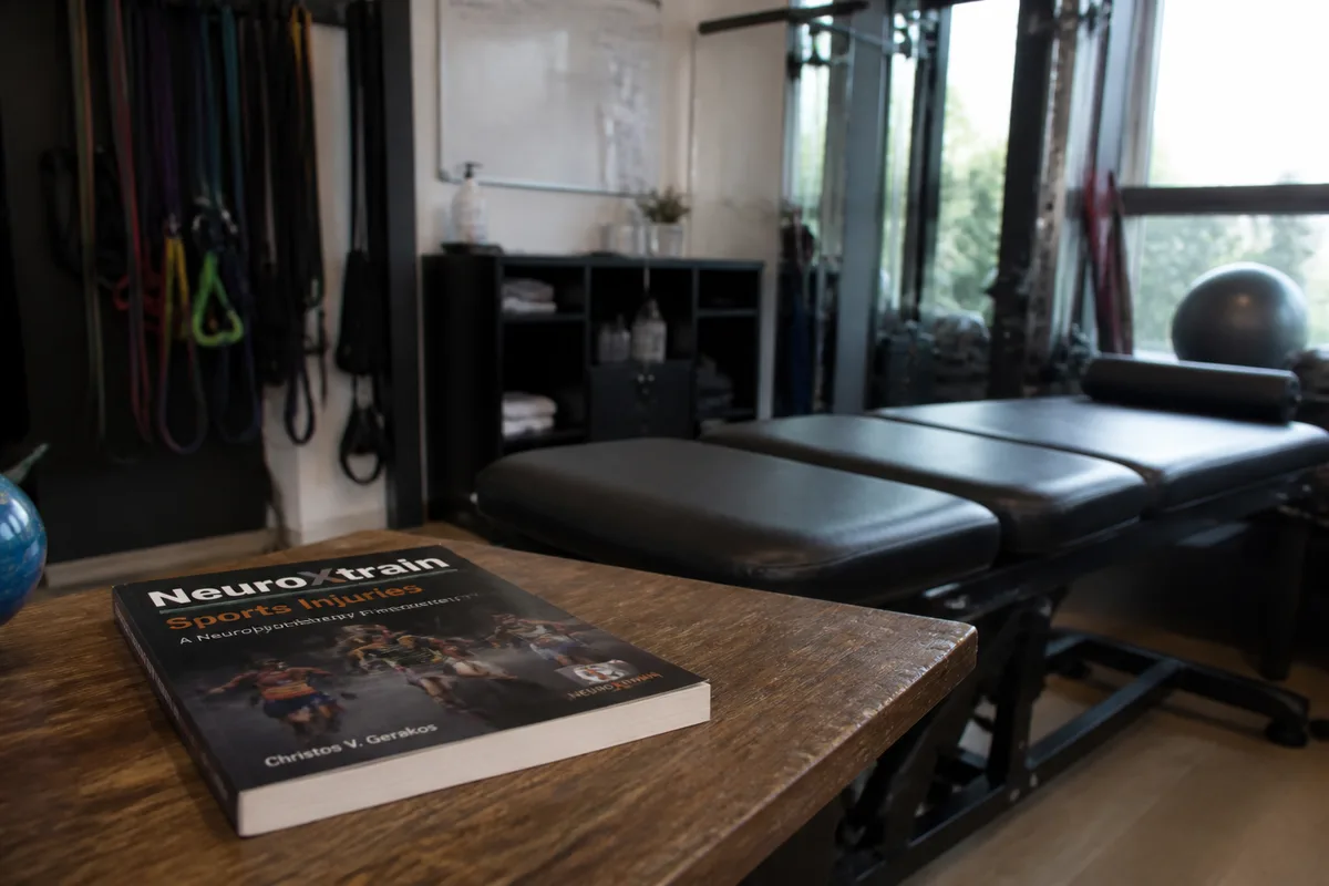 Livre NeuroXtrain sur les blessures sportives posé dans un cabinet de rééducation