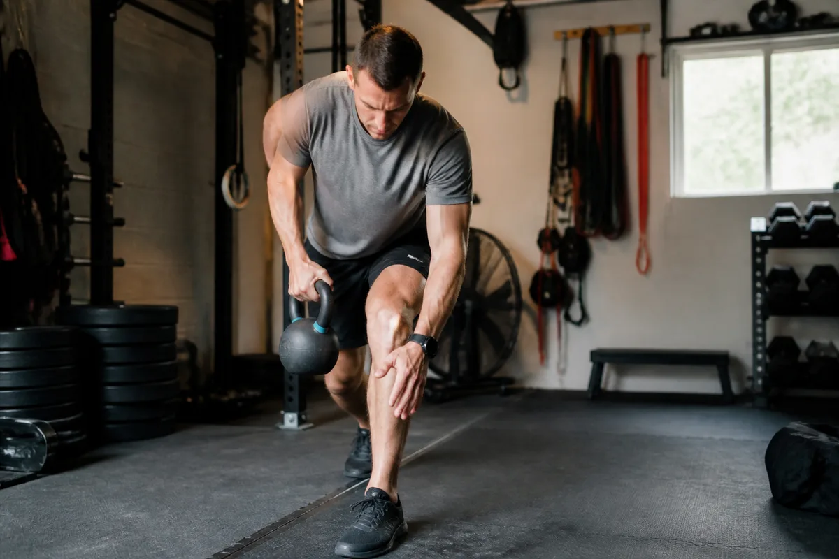 Sportif réalisant un exercice d’entraînement fonctionnel en salle avec une technique contrôlée
